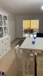 a white dining room with a table and chairs at Oliveres in Hospitalet de l'Infant