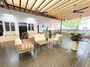 a patio with chairs and a table on a wooden floor at The Snooze Hotel Marine Parade in Singapore
