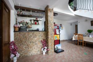 a room with a stone wall with flowers on it at Pensiunea Poarta Apusenilor in Moldoveneşti