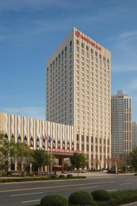 um grande edifício branco em frente a uma rua em Wanda Realm Chifeng Hotel em Chifeng