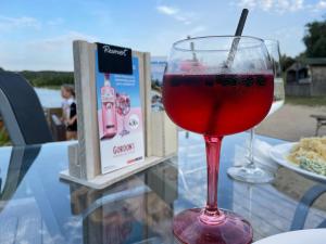 un bicchiere di vino rosso appoggiato su un tavolo di Haus TAO, am See a Zirkow Altre 11 foto
