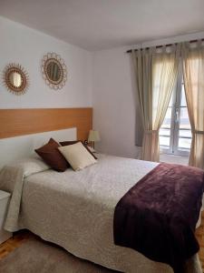 a bedroom with a bed and a mirror and a window at A Parada do Camiño in Arzúa