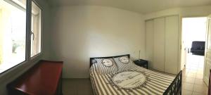 a small bedroom with a bed with a striped blanket at Bas de maison de village cosy & relax in Vero
