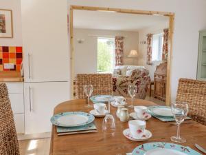 a dining room with a wooden table and chairs at Orchard Cottage in Derby