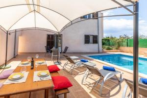 un patio avec une table et des chaises à côté d'une piscine dans l'établissement Ariany - 38358 Mallorca, à Ariany