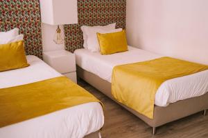 
a hotel room with two beds and two lamps at Top'Otel in Barcelos
