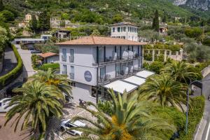 an aerial view of a white building with palm trees at Hotel Livia in Gargnano