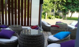 a group of wicker chairs with colorful pillows on a patio at Motel Park Rogatica in Rogatica