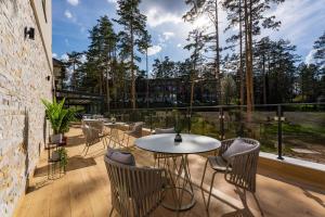 a patio with tables and chairs on a balcony at Konak Apartmani & SPA in Zlatibor