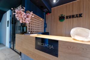 a reception counter with a vase of flowers on it at Konak Apartmani & SPA in Zlatibor