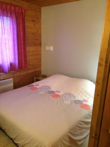 Un dormitorio con una cama blanca con flores. en Duplex dans chalet au coeur de la station, en Réallon