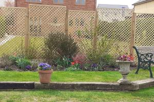einen Garten mit einer Bank, Blumen und einem Zaun in der Unterkunft The Annexe, Cornfields in Elmswell