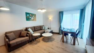 sala de estar con sofá y mesa en Apartamenty Aleksandry _ Flotylla, en Świnoujście