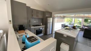 a kitchen with a blue chair in the middle of it at Callala Beach Winter Warmers in Callala Beach