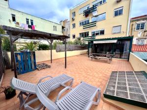 un patio con 2 sillas y una mesa y un edificio en Flores Terrace Apartment, en Lisboa