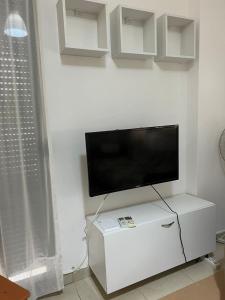 TV de pantalla plana en la parte superior de un armario blanco en Seaside apartment N3 Golem, en Golem