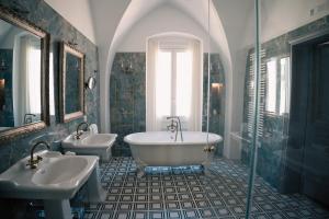 uma casa de banho com 2 lavatórios e uma banheira em The Duchess's View - NEW! Luxurious Flat in Historical Centre 115 sq m, 3min walk to Cala Porto beach and Private Parking em Polignano a Mare