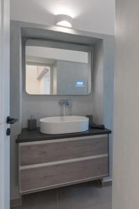 a bathroom with a sink and a mirror at Akro Luxury Living in Astypalaia