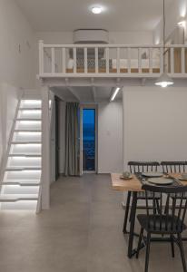 a loft bed in a living room with a table and chairs at Akro Luxury Living in Astypalaia