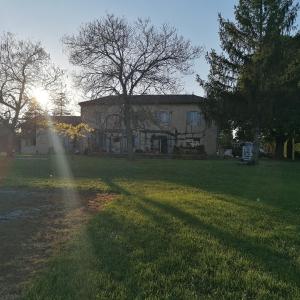 a house in a yard with the sun shining on it at Le Marronnier in Saint-Vincent-de-Pertignas