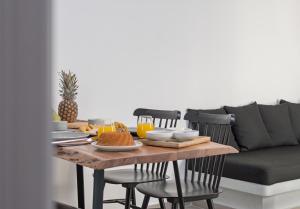 a dining room table with breakfast foods and a couch at Akro Astypalea in Astypalaia +17 photos