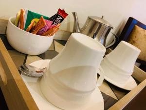 eine Theke mit zwei weißen Tassen und einer Schale Chips in der Unterkunft ISIS Hôtel in Jaunde