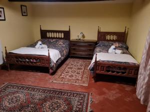 a bedroom with two beds and a rug at Casa rural Finca Requejo cerca de Benavente TR 49426 in Manganeses de la Polvorosa +66 photos