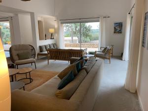 a living room with a couch and some chairs at Villa Arbevhio in Bonifacio