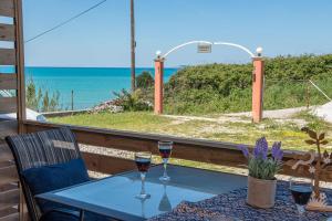 una mesa con 2 copas de vino en el balcón en Darmanin Αpartment 4 Gyalos Corfu, en Astrakeri