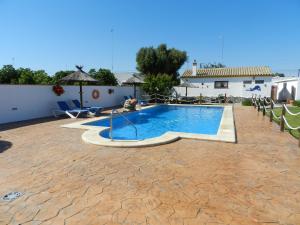 a swimming pool in a yard with chairs and a building at Casas Arena y Mar in Zahora