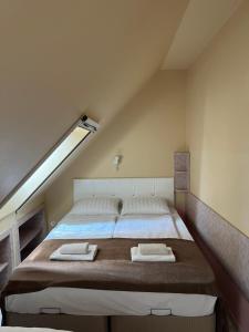 a bedroom with a large bed in a attic at Irini Panzió in Budapest