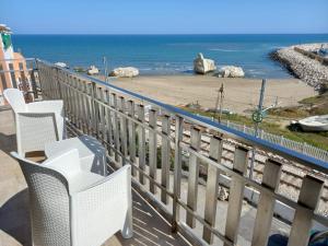 balcone con sedie e vista sulla spiaggia di AMARE Bed & Breakfast a Rodi Garganico