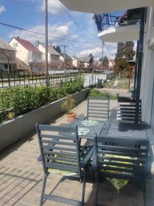 drie stoelen en een tafel op een veranda met uitzicht bij BM Apartman in Zalakaros