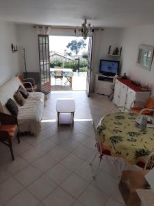 a living room with a couch and a table at Villa mitoyenne, 100m des plages - 3 chambres- in Sagone