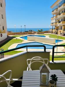 una mesa y sillas en un balcón con piscina en Apartment Sea Breeze – Apartamento Brisas del Mar, en Benalmádena
