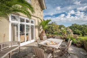 patio con mesa, sillas y ventana en Lisle Combe, en Ventnor