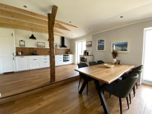 a kitchen and dining room with a wooden table and chairs at Ferienwohnung Watt'n Ausblick in Simonsberg