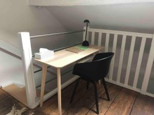 a desk with two chairs and a lamp on it at A Côté, c'est aussi chez vous ! in Namur