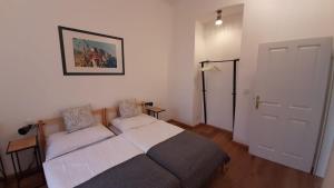 ein kleines Schlafzimmer mit einem Bett und einer Tür in der Unterkunft Pia's Gardenview in Wien