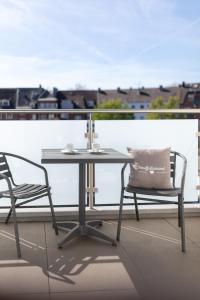 una mesa y 2 sillas sentadas en un balcón en cityhotel, en Bocholt