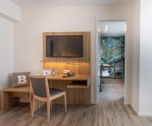 a room with a desk with a television on a wall at cityhotel in Bocholt