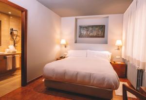 a bedroom with a large bed and a bathroom at Abba Xalet Suites Hotel in Sispony