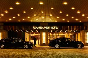 2 auto parcheggiate di fronte a un hotel con vista akasha di Asakusa View Hotel a Tokyo