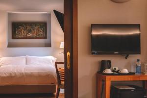 a hotel room with a bed and a television at Abba Xalet Suites Hotel in Sispony