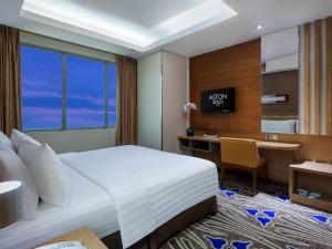 a hotel room with a bed and a desk at ASTON Solo Hotel in Solo