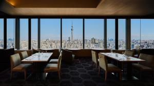 
a dining room table with chairs and a large window at Asakusa View Hotel in Tokyo
