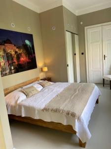 a bedroom with a large bed with a painting on the wall at Loft Àpropos in Sankt Georgen an der Stiefing