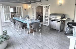 a kitchen with a table and chairs and a grill at Summer House in Hermanus