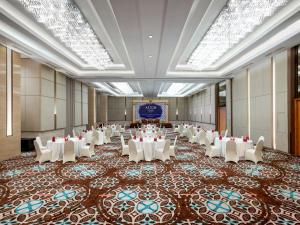 a banquet hall with white tables and white chairs at ASTON Solo Hotel in Solo