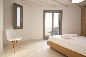 a white bedroom with a white bed and a white chair at Dreamy Cycladic Luxury Summer House 2 in Serifos Chora